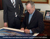 George HW Bush autographs the prints